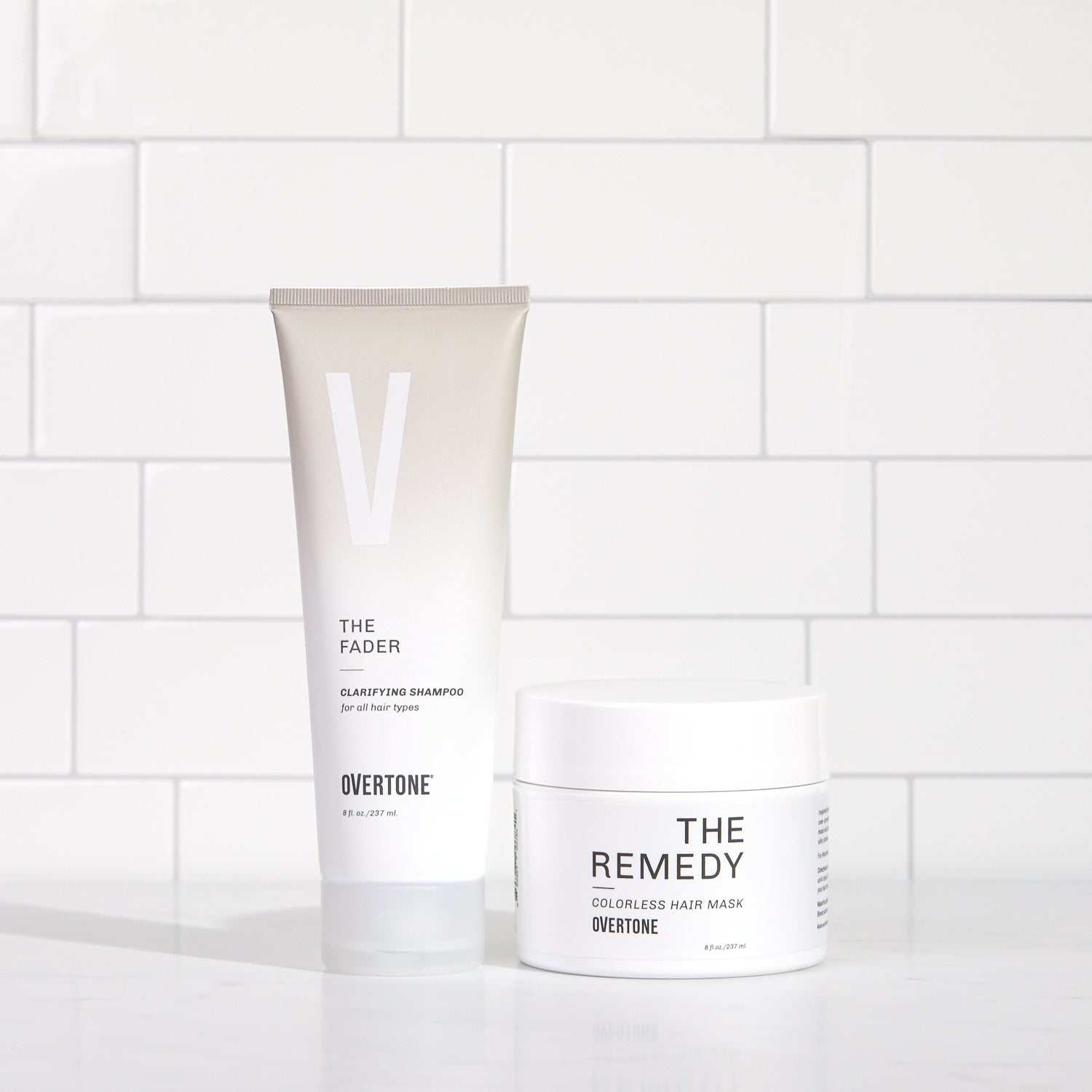 color fading shampoo and hydrating hair mask on white shower shelf