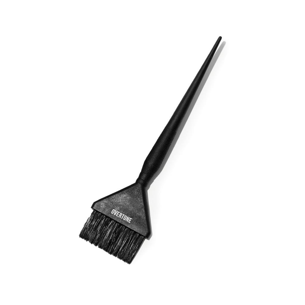 Black hair dye brush with Overtone branding on a white background
