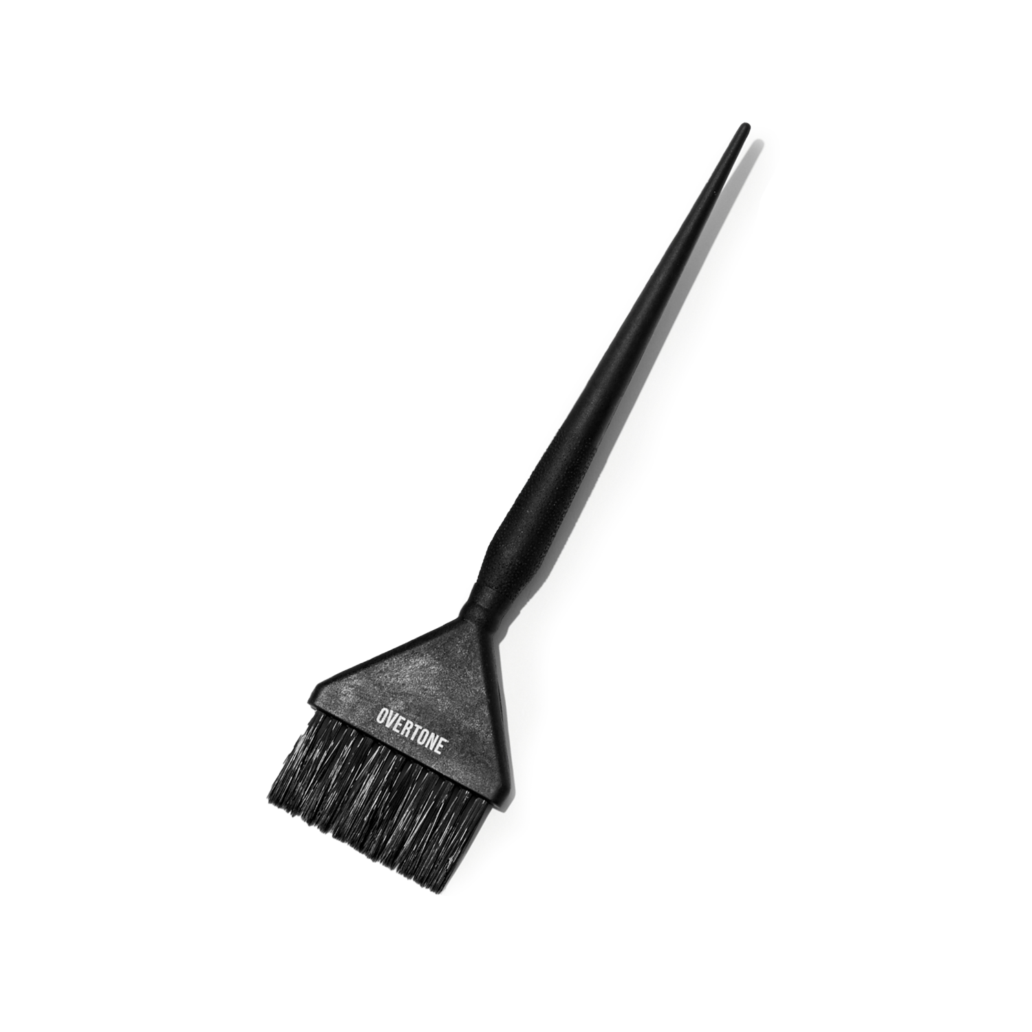 Black hair dye brush with Overtone branding on a white background