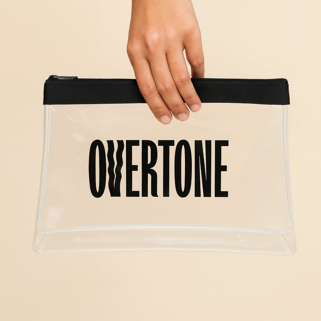 Clear pouch with 'Overtone' text held by a hand against a beige background
