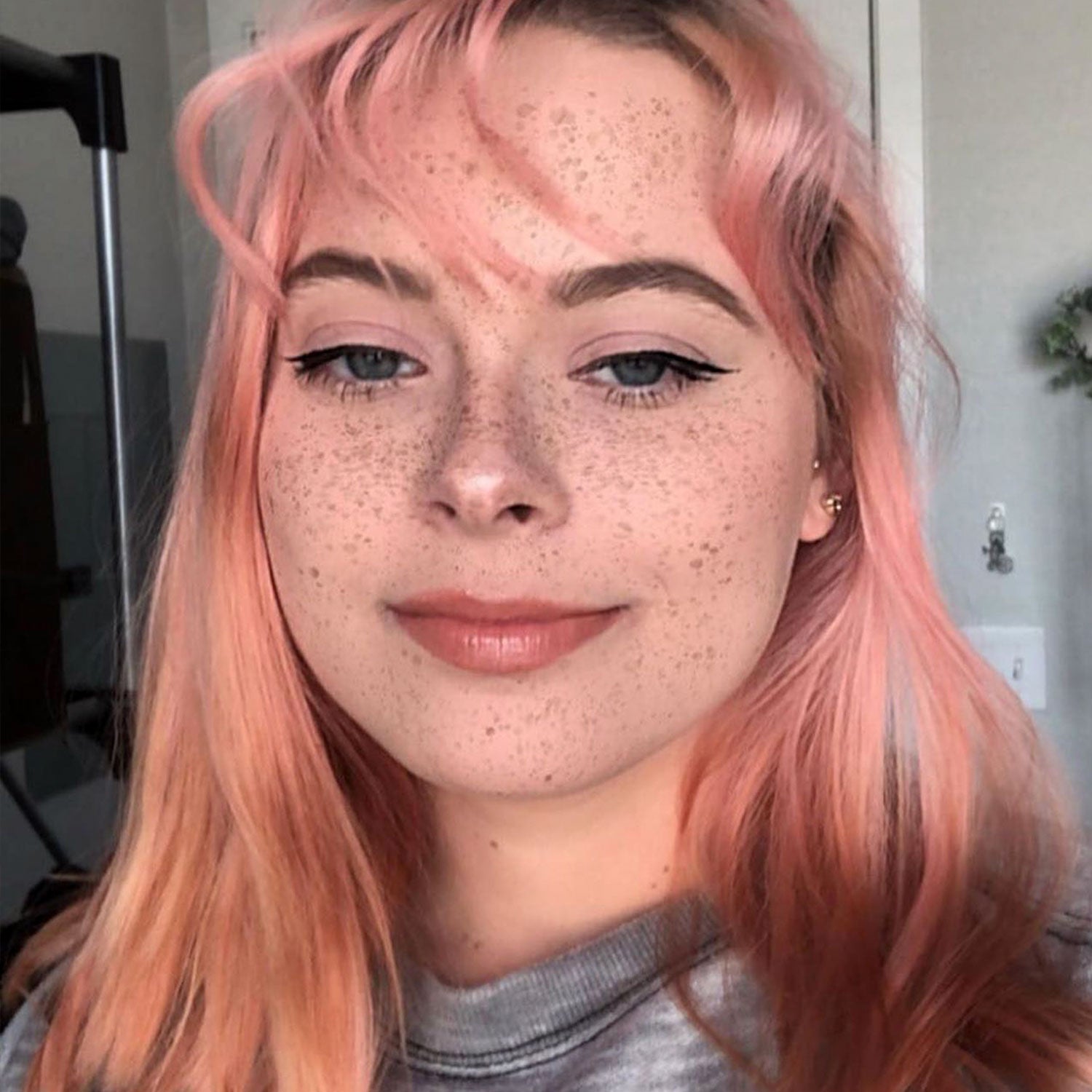 person with rose gold hair color with bangs, on pre-lightened long hair