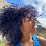 person with deep blue hair color on natural, short coily brown hair
