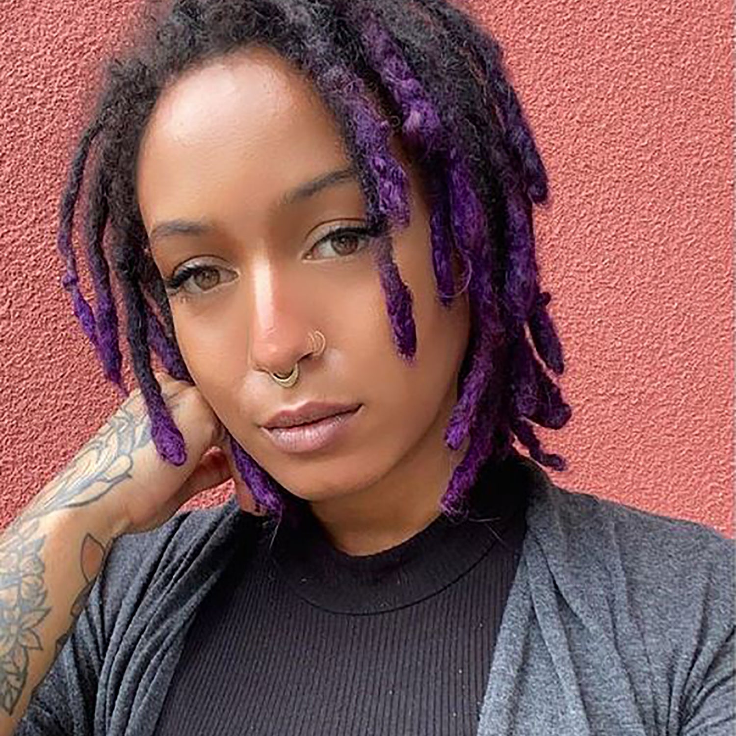 person with violet purple hair color dip dye on pre-lightened locs