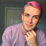 person with short pastel magenta hair color on pre-lightened hair