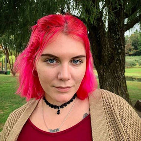 person with extreme pink hair color on short pre-lightened hair