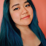 person with teal hair color on shoulder length pre-lightened long hair